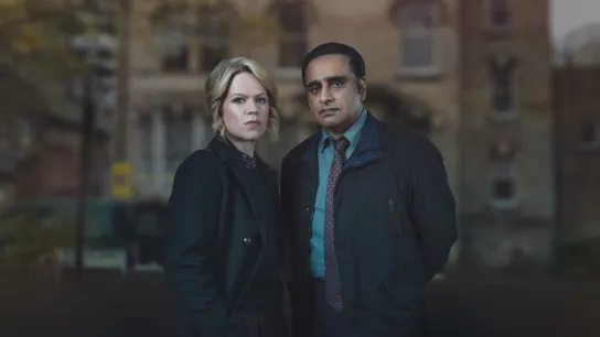 DCI Jess James (played by SINÉAD KEENAN) & DI Sunny Khan (played by SANJEEV BHASKAR) standing side by side.
